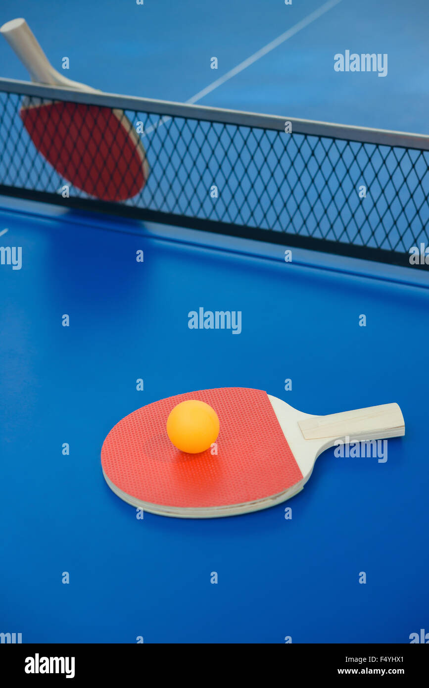 pingpong rackets and ball on a blue pingpong table Stock Photo