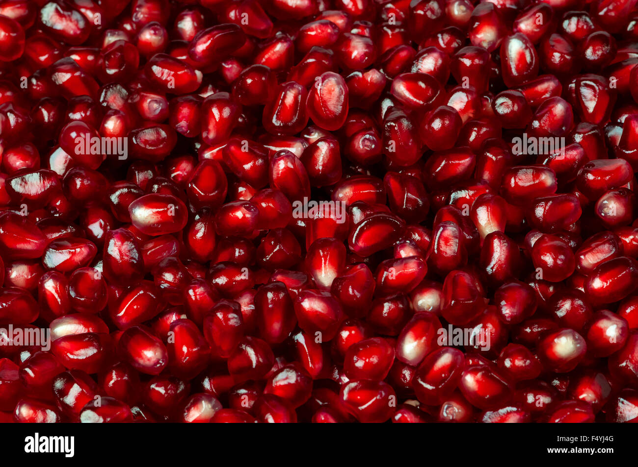 Delicious red ripe juicy pomegranate seed background texture Stock Photo
