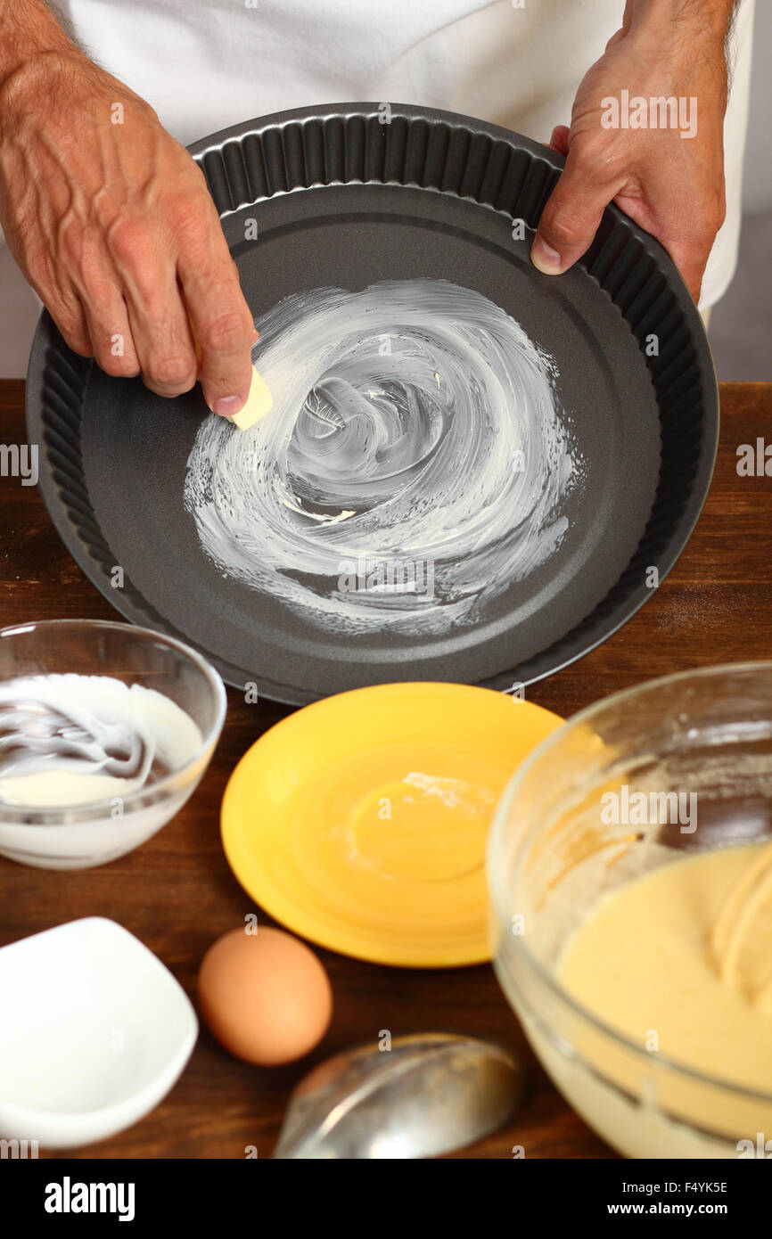 Making Sour Cream Lemon Cake. Preparing Cake Pans For Baking. Greasing with margarine or butter. Stock Photo