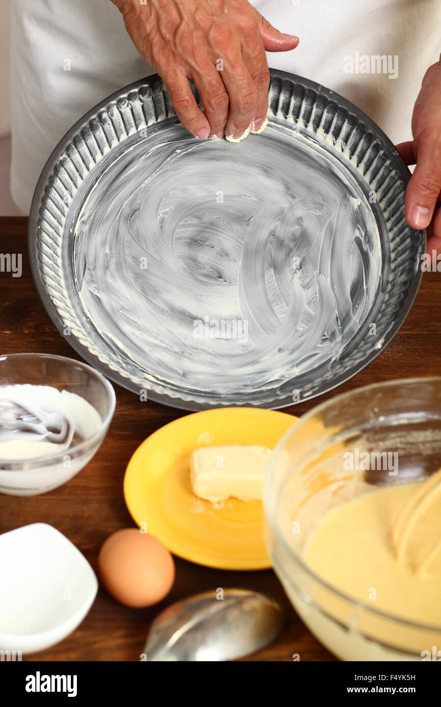 Making Sour Cream Lemon Cake. Preparing Cake Pans For Baking. Greasing with margarine or butter. Stock Photo