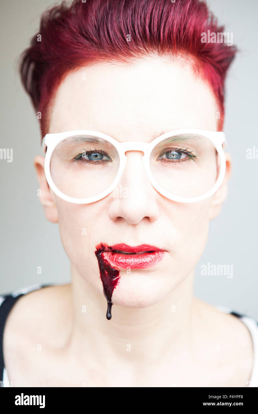 portrait of red-haired woman with bloody mouth Stock Photo
