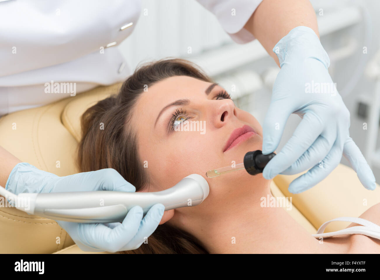 Cosmetic injection to the pretty caucasian woman face and beautician ...
