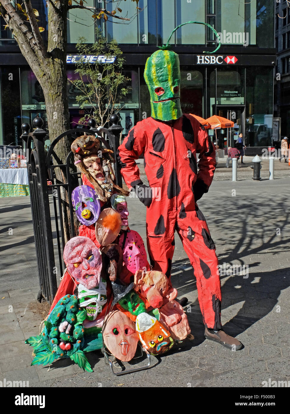 New York City visual artist James McGann in his watermelonman mask near his unusual Halloween masks for sale in Union Square Stock Photo