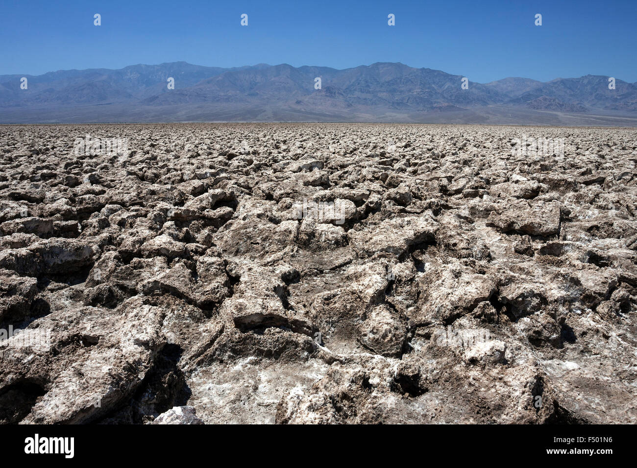 Salt structures on Devil's Golf Course, Panamint Range behind, Black Mountains, Death Valley National Park, Mojave Desert Stock Photo