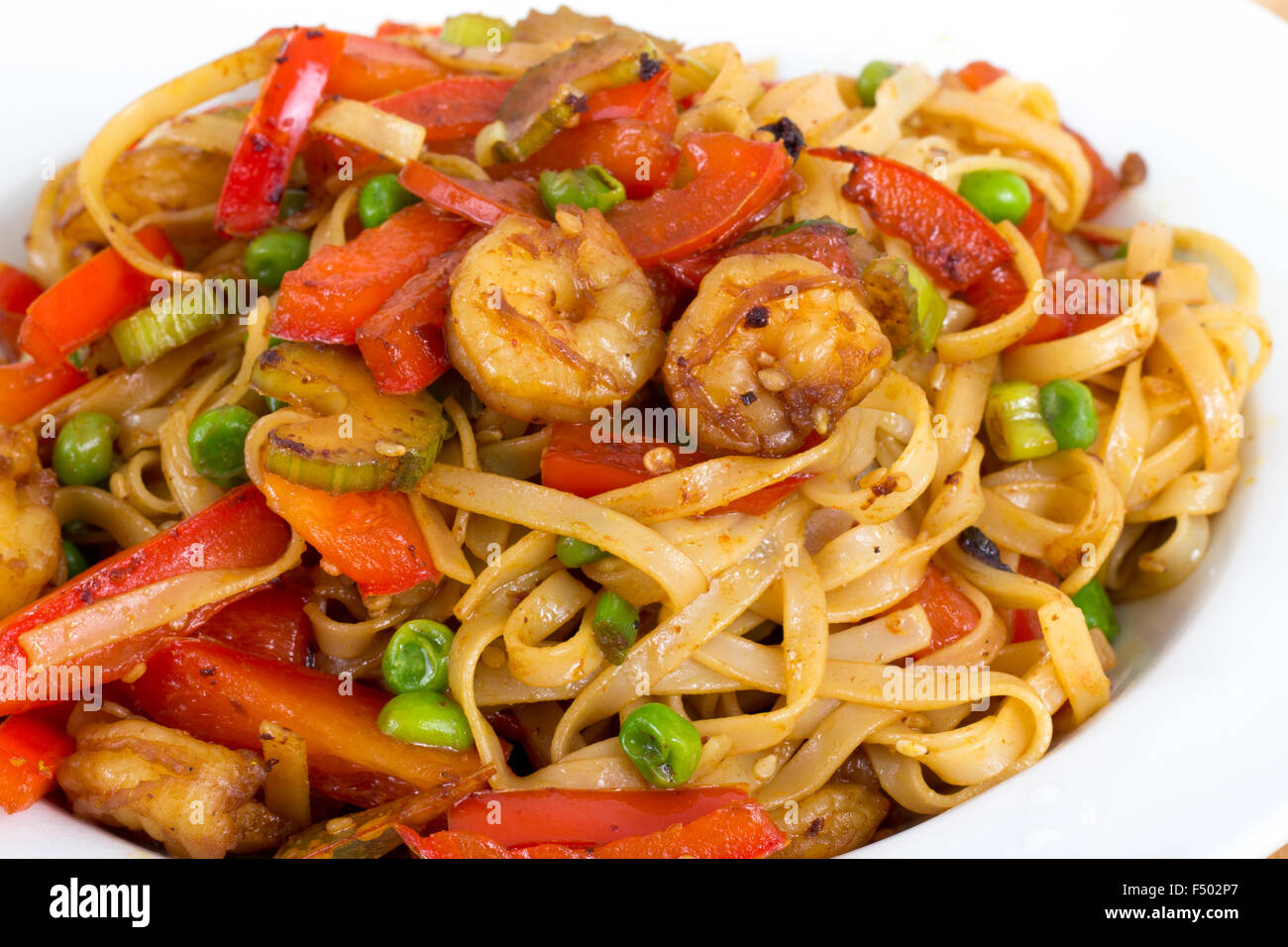 Shrimp stir fried with pasta and red bell pepper in a bowl Stock Photo