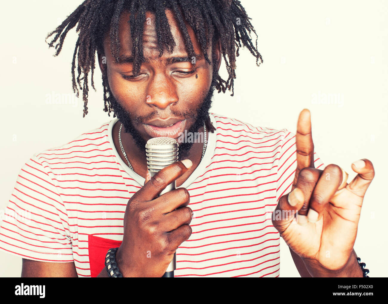 young handsome african american boy singing emotional with microphone
