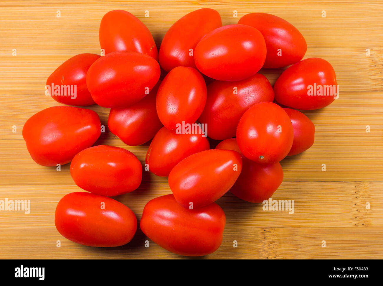 Tomatoes branch on the wood background Stock Photo - Alamy