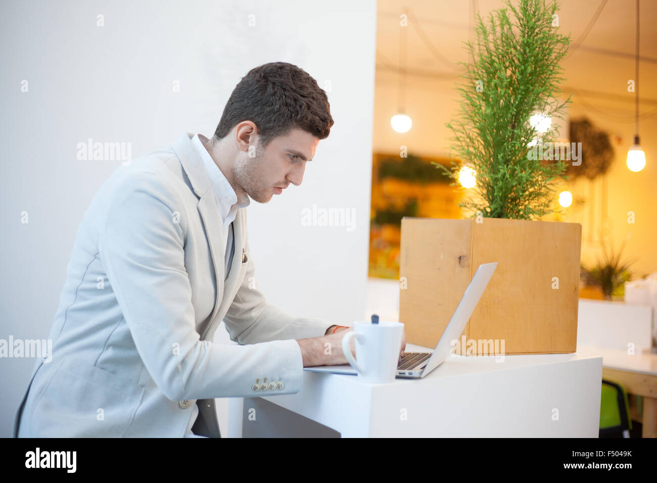 Man using laptop in white office Stock Photo