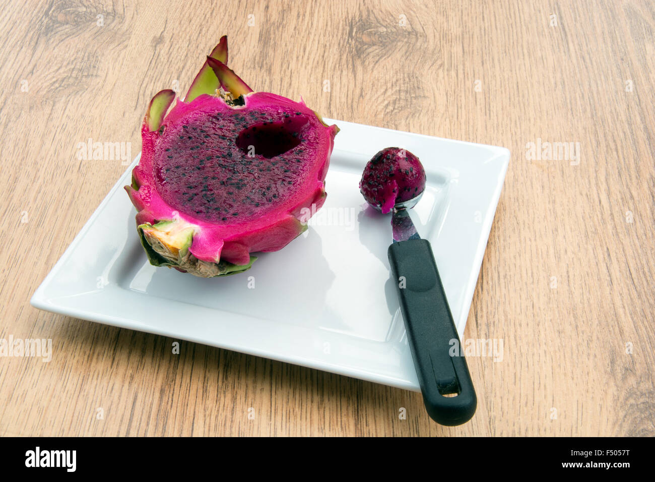 Dragon fruit cut open and piece scooped out Stock Photo