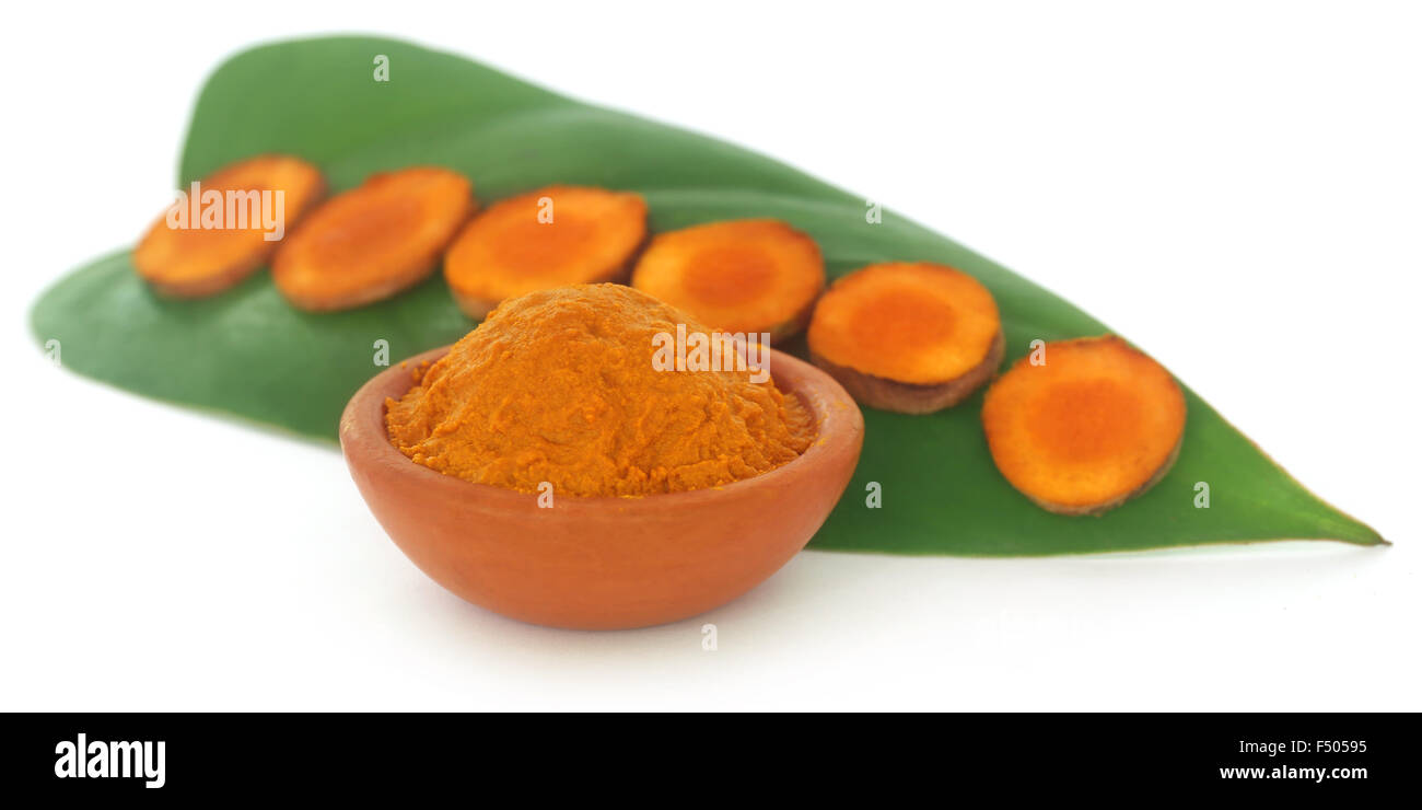 Raw turmeric with green leaves over white background Stock Photo - Alamy