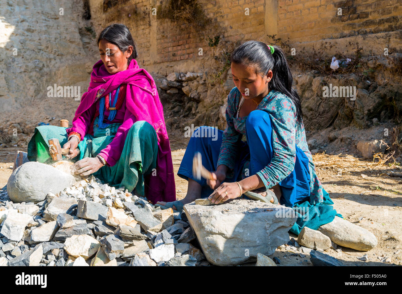 2 women cutting stones with a hammer Stock Photo Alamy