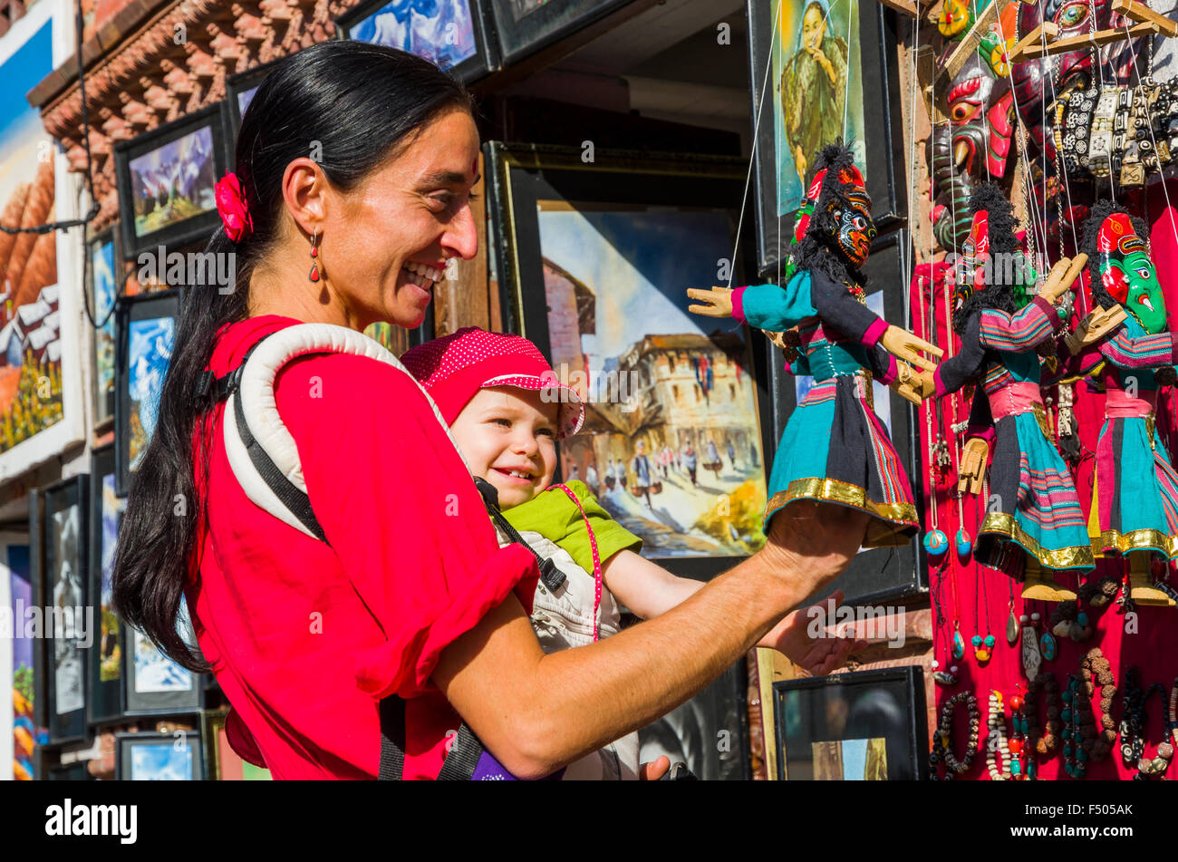 Young tourist mother with child looking at souvenir puppets Stock Photo