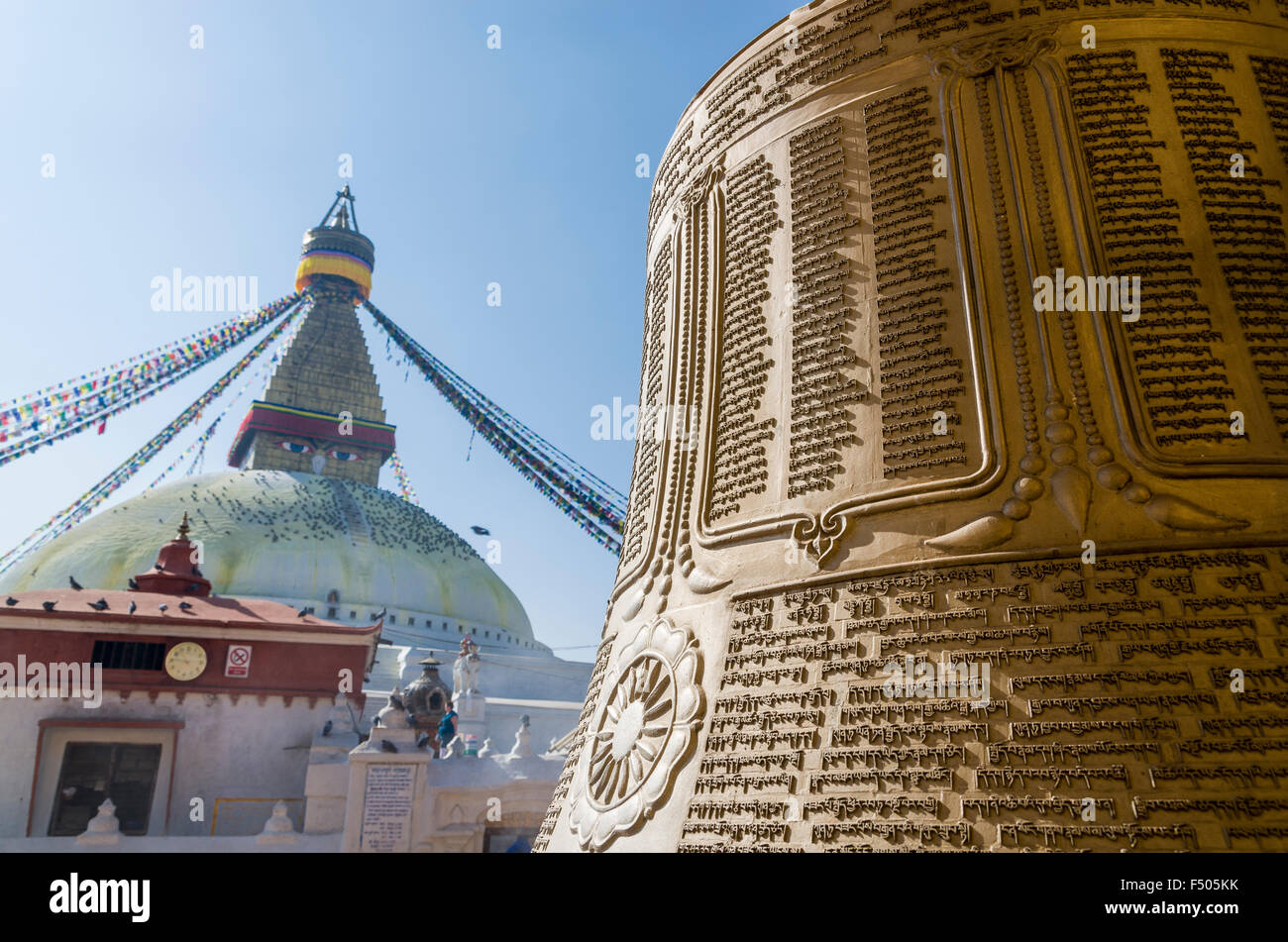 Big bell with inscription in tibetean language with Boudnath Stupa in the background Stock Photo