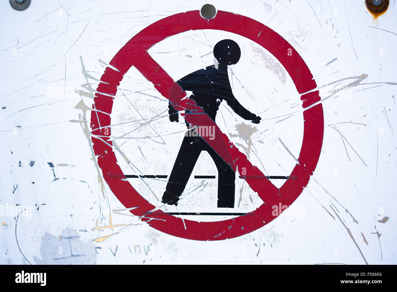 A scratched and weathered no walking / no entry sign Stock Photo