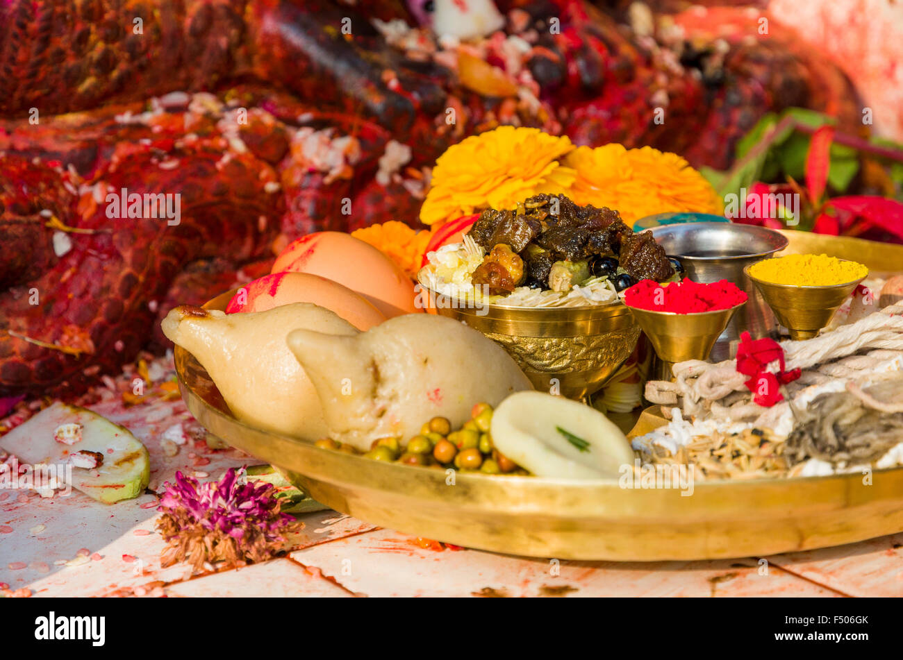 Flowers, food, colorpowder, eggs and candles as offerings to the Gods on a metal plate Stock Photo