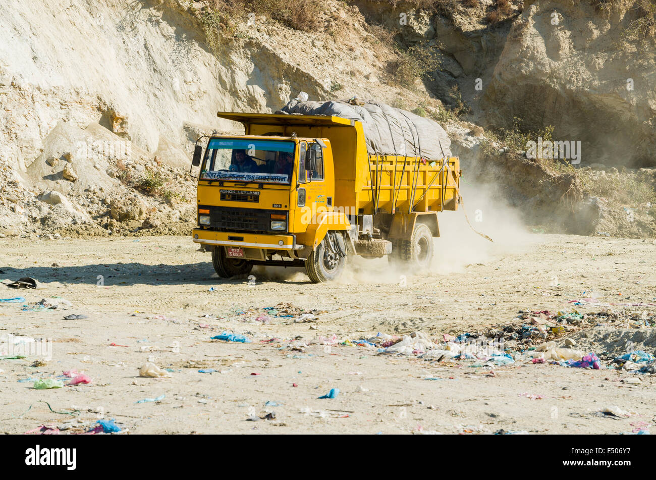 Yellow truck loaded with garbage from Kathmandu arriving at Aletar garbage dump Stock Photo