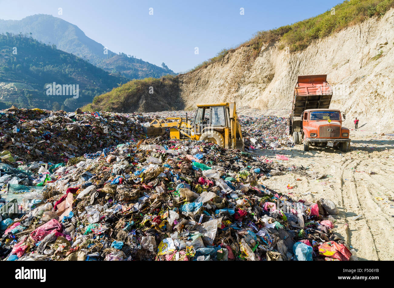 Orange truck delivering garbage from Kathmandu at Aletar garbage dump Stock Photo