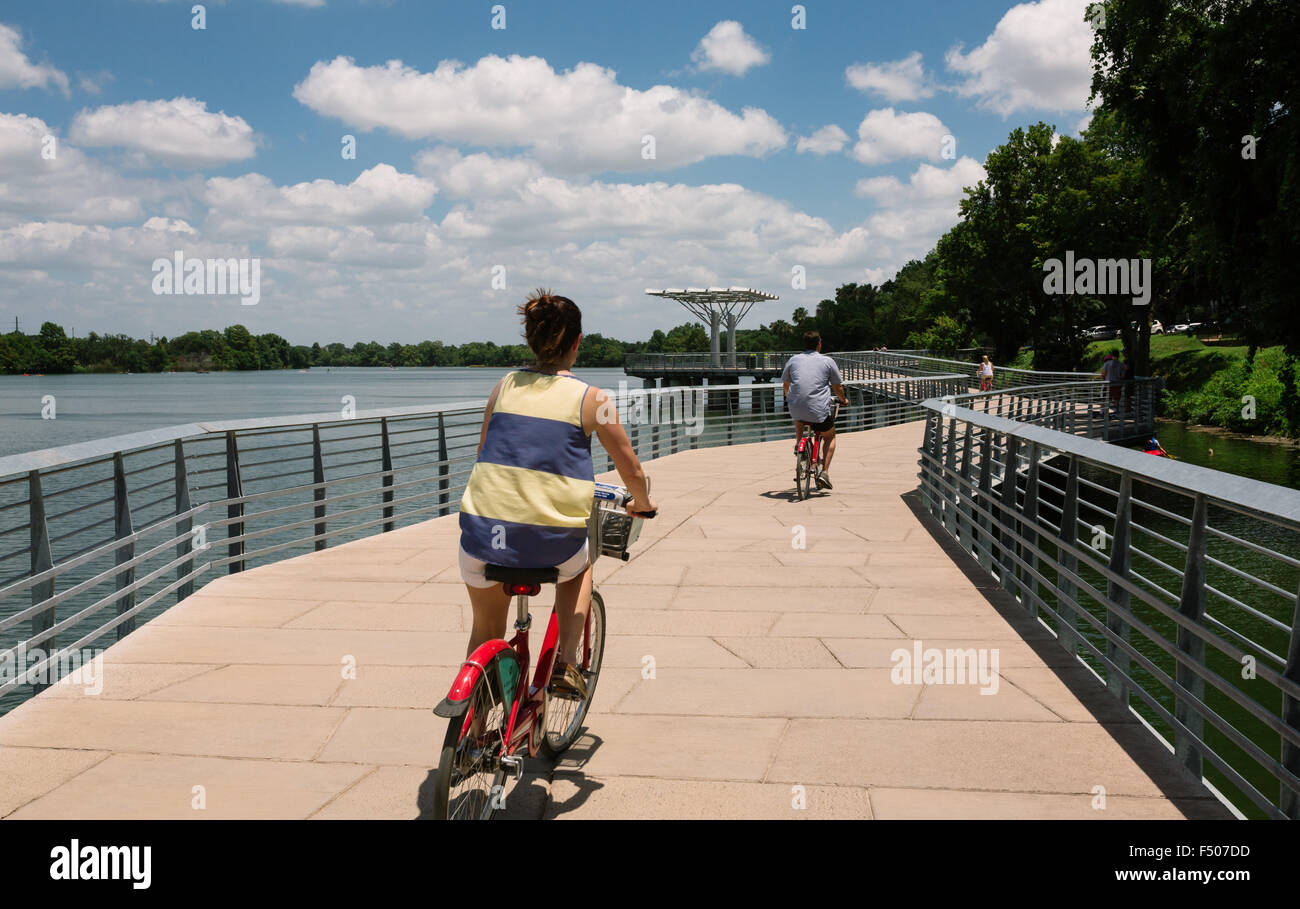 Bicyclists ride on the Austin Boardwalk over Ladybird Lake near downtown Stock Photo