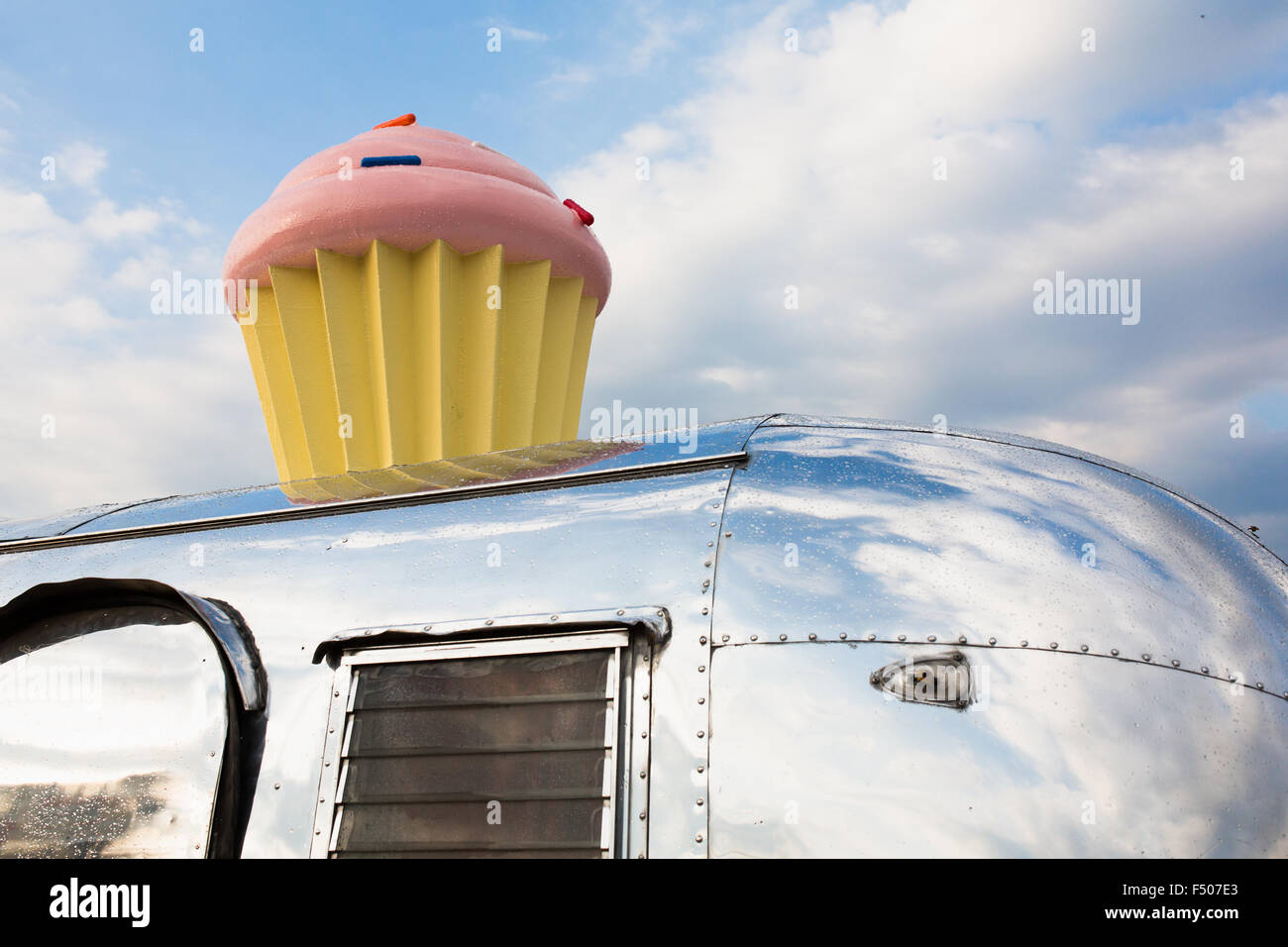 Hey Cupcake in Austin, Texas: A pink cupcake sign on top of a silver metallic trailer Stock Photo