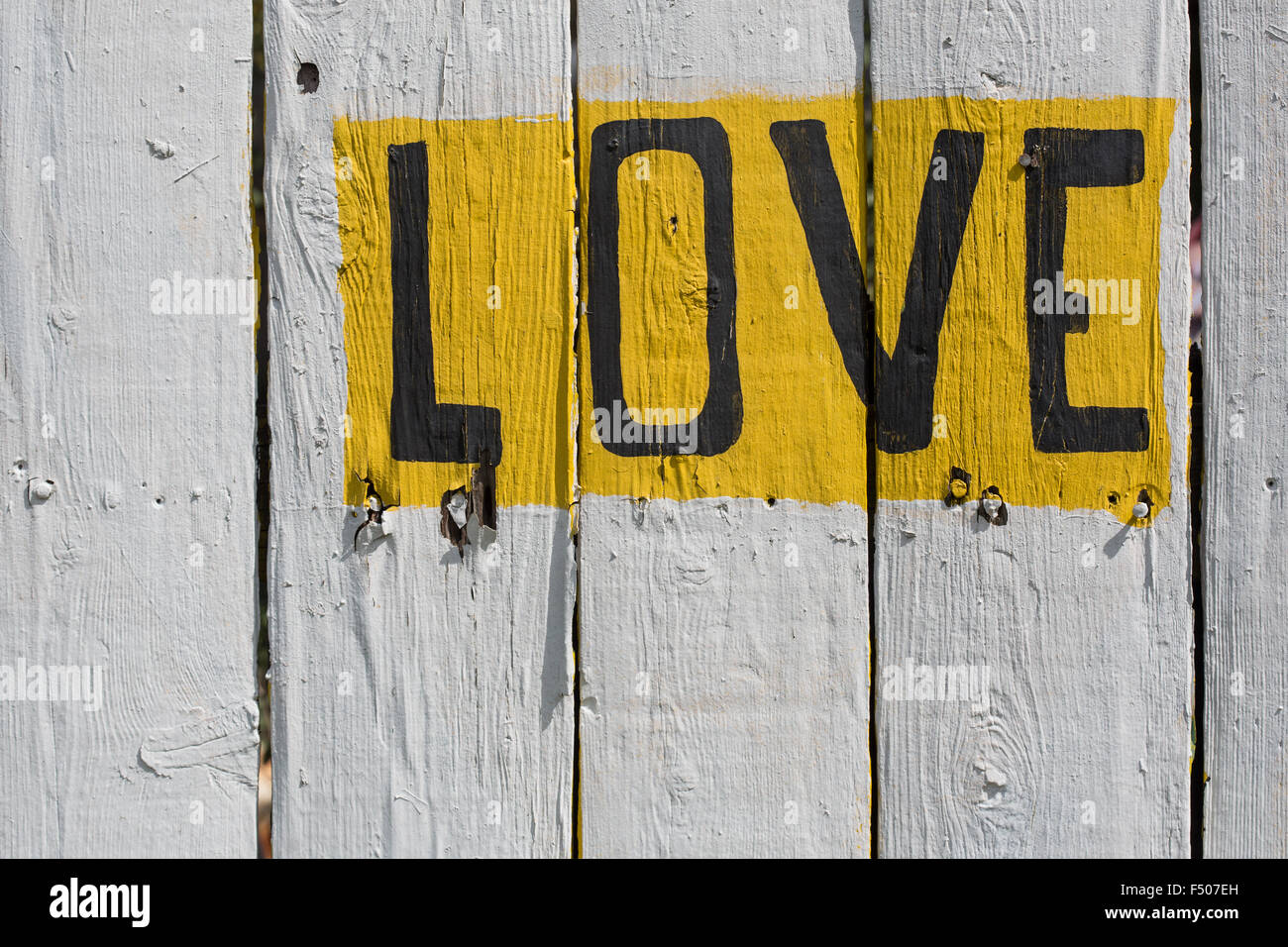 The word 'LOVE' written on a whitewashed fence Stock Photo