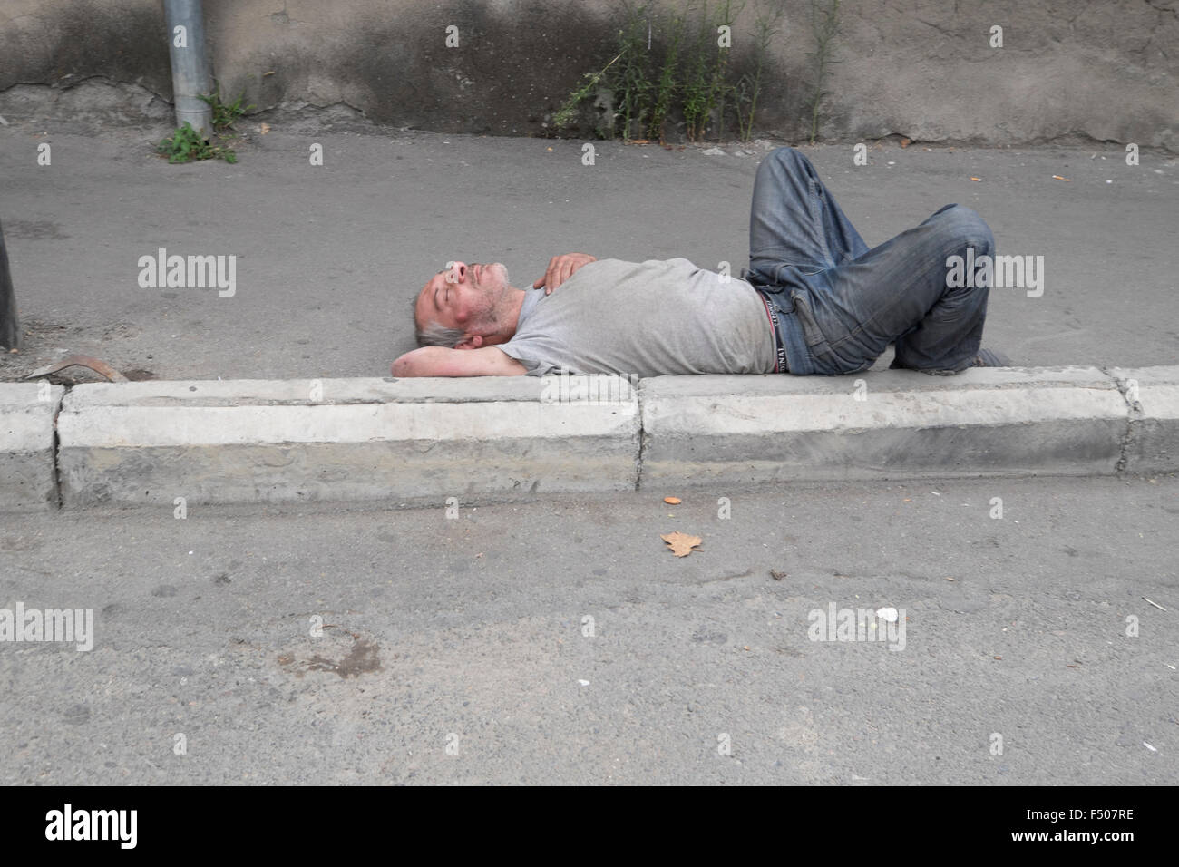 Drunk sleeping in the street, Tbilisi, Georgia Stock Photo