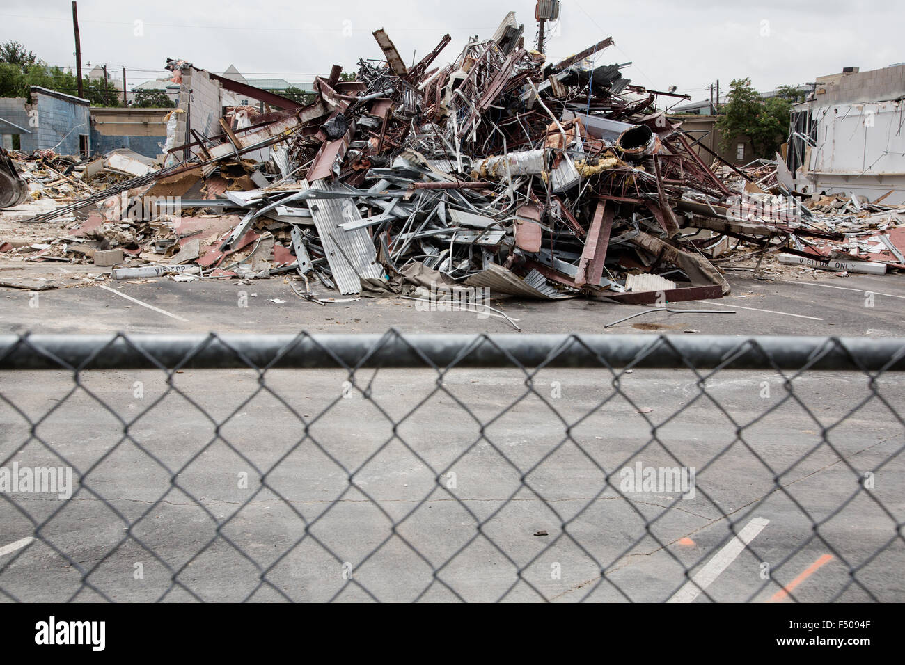 The rubble of a demolished building behind a chain link fence Stock ...