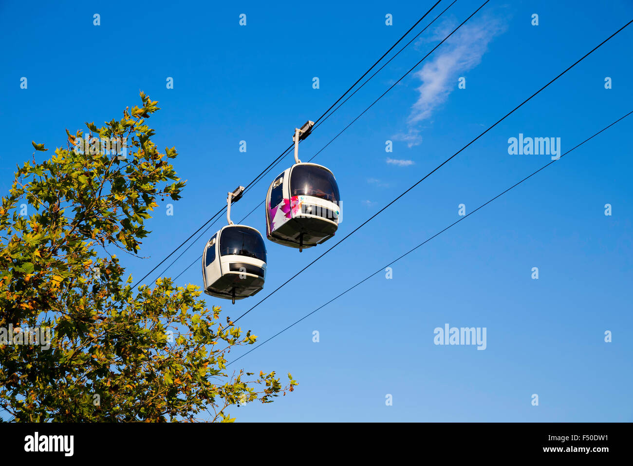 Two cable cars in motion in the air with  blue sky background Stock Photo