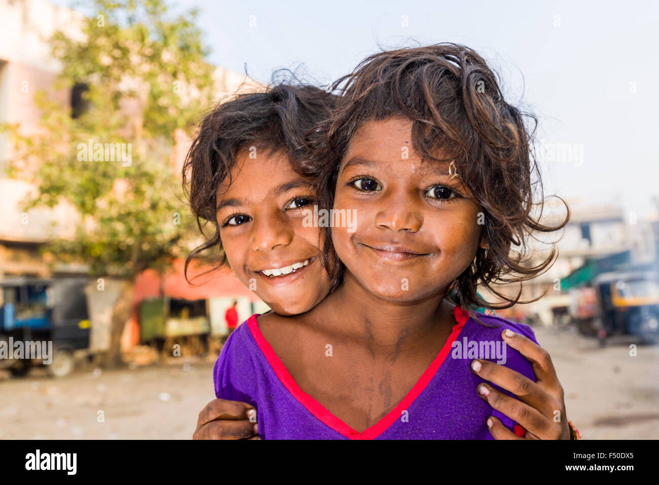 Portraits of two smiling street kids, children, who are living just beside busy roads on the pavement Stock Photo