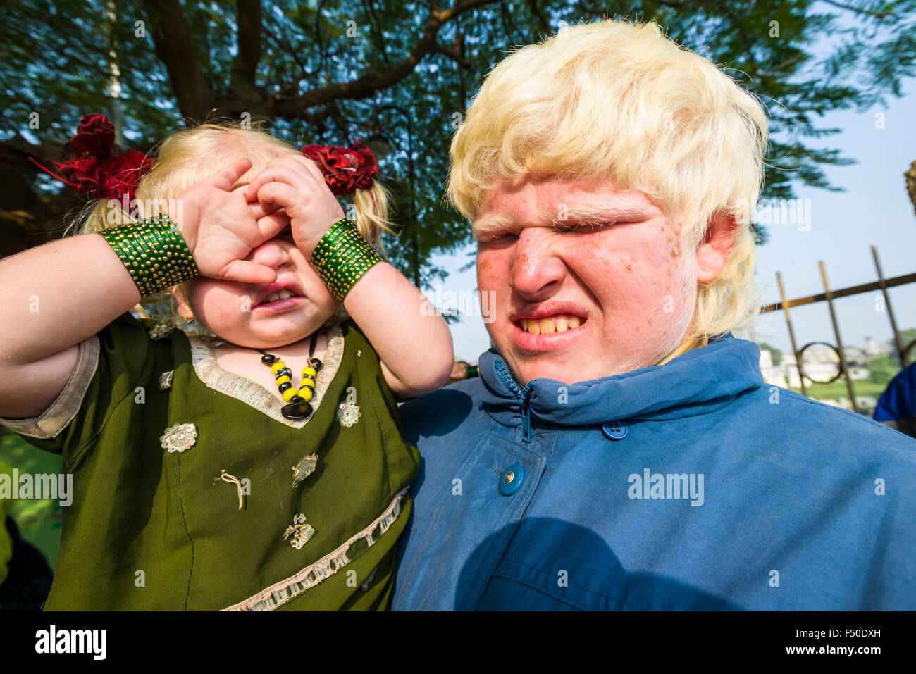 Portraits of Albinos with extremely pale skin and near-white hair, covering their eyes from the sunlight Stock Photo