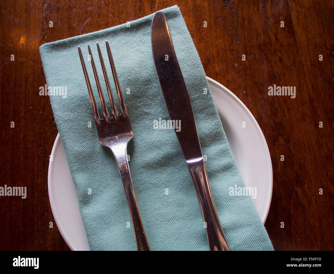 Silverware arranged on a napkin and plate Stock Photo