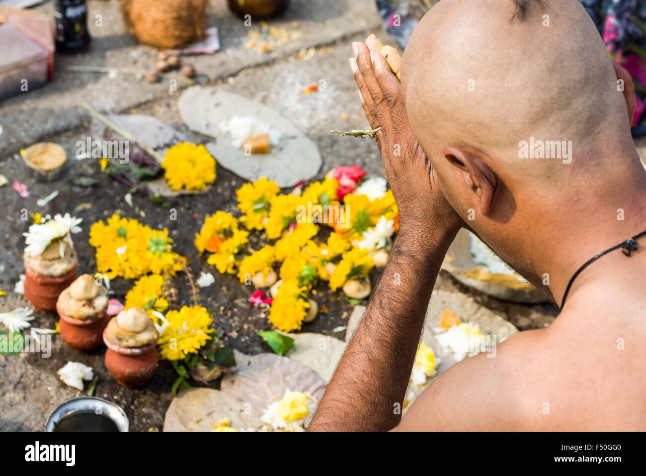 A man is praying during the ritual Dashkriya or Asthi Visarjan, a ...