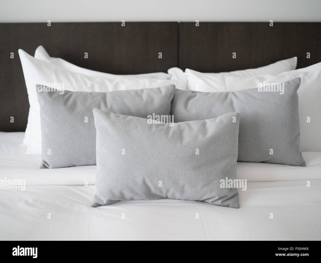 Decorative pillows lined up on a bed Stock Photo