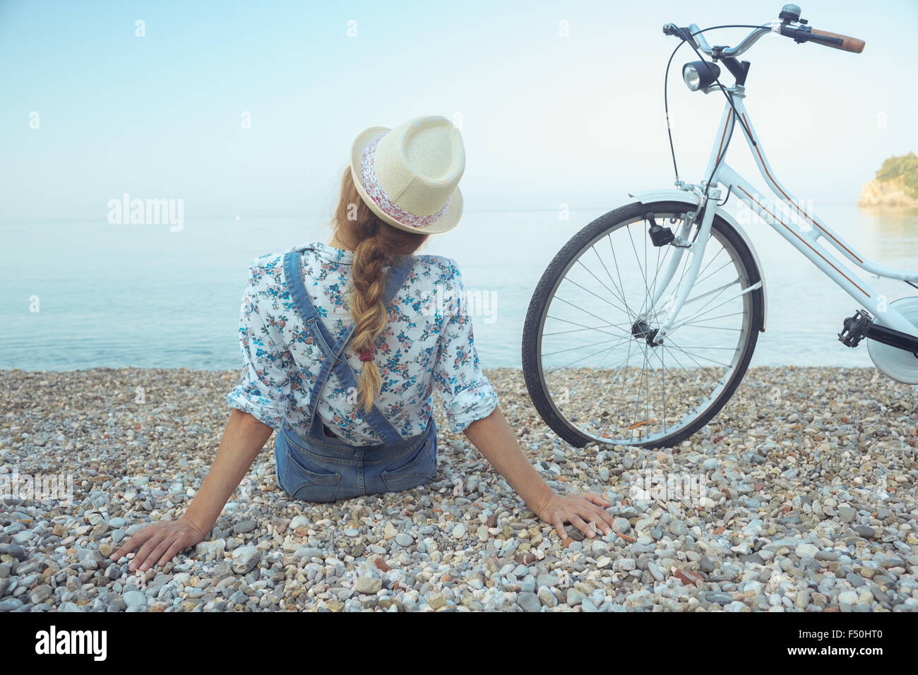 Happy woman with bicycle on the beach - view from the back Stock Photo