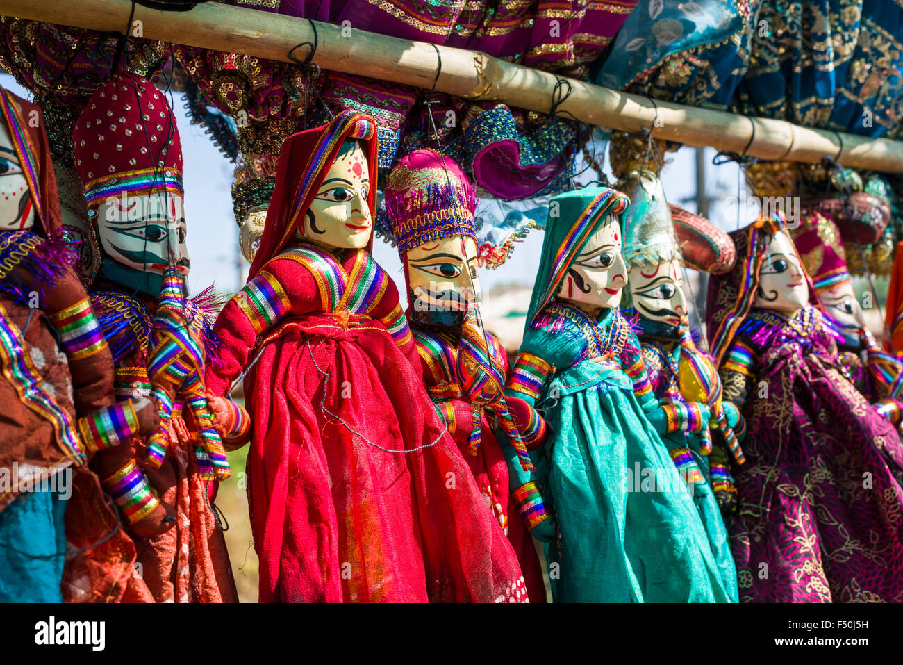 Many different goods like artfully designed rajasthany string puppets are presented for sale at the weekly fleamarket Stock Photo