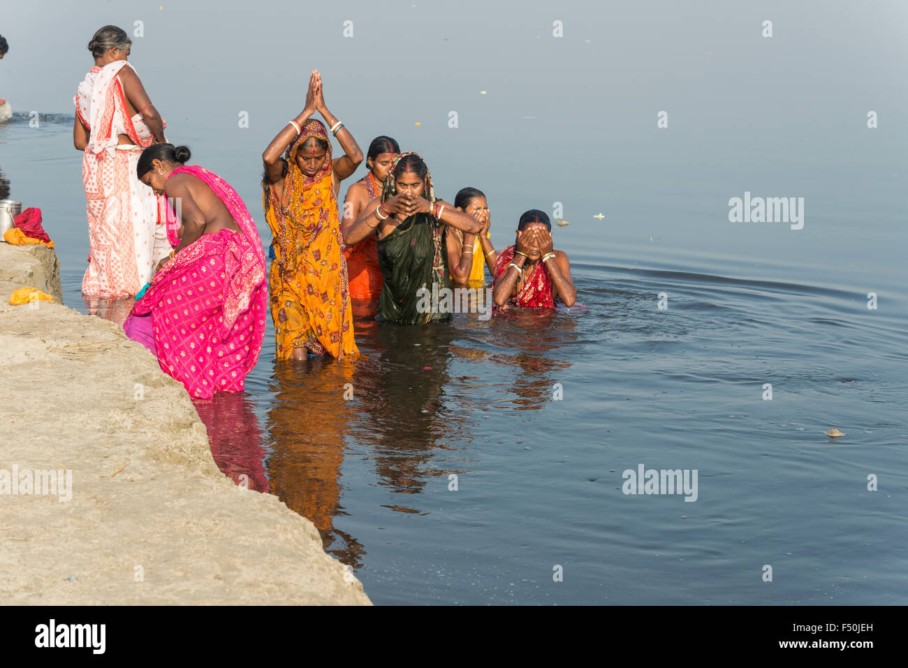 A group of female pilgrims, women, is taking bath and praying in the holy river Yamuna Stock Photo