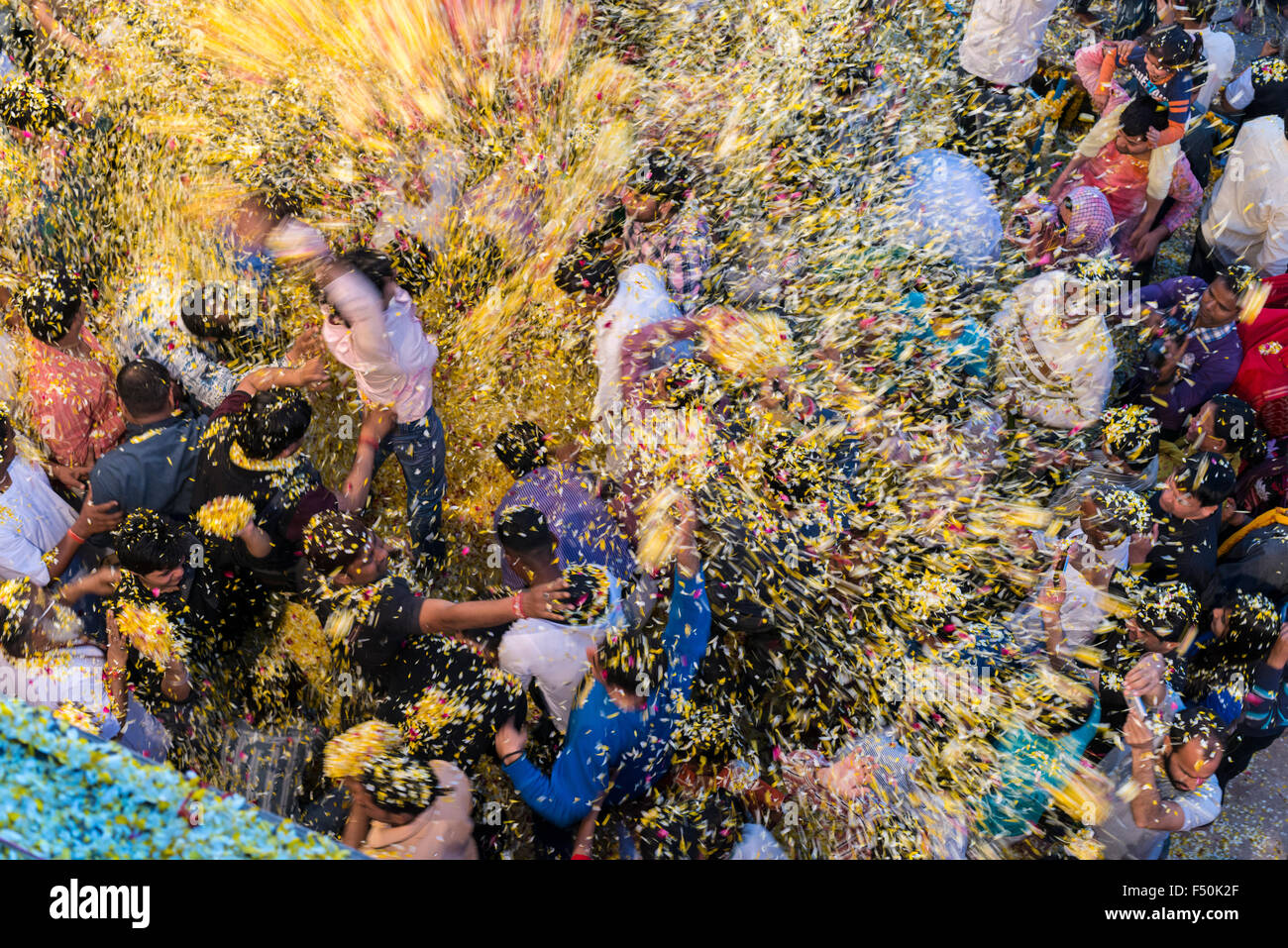 Many pilgrims, women and men, are celebrating a ritual, pooja, by throwing flowers in the air on the ghats at the holy river Yam Stock Photo