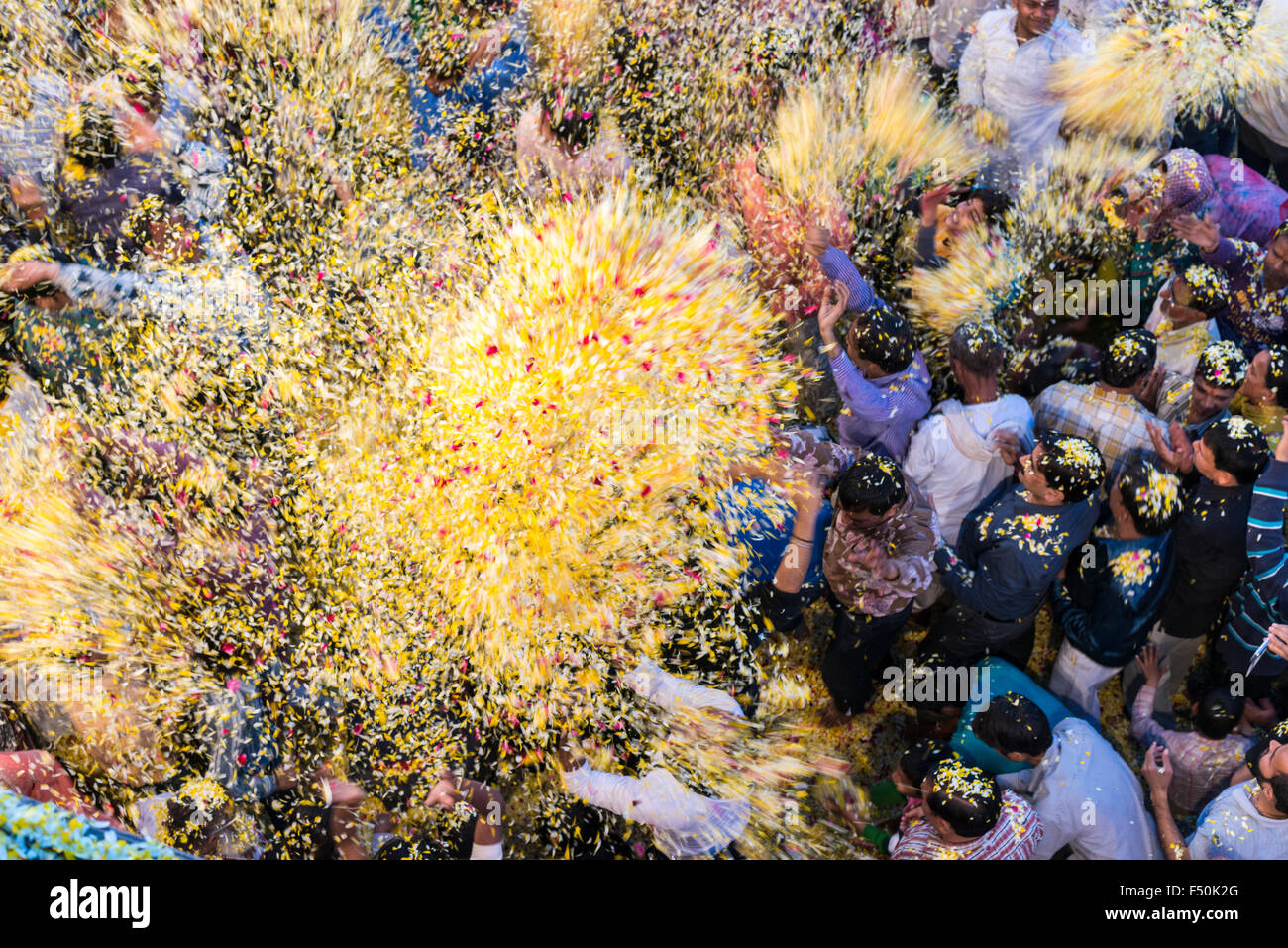 Many pilgrims, women and men, are celebrating a ritual, pooja, by throwing flowers in the air on the ghats at the holy river Yam Stock Photo