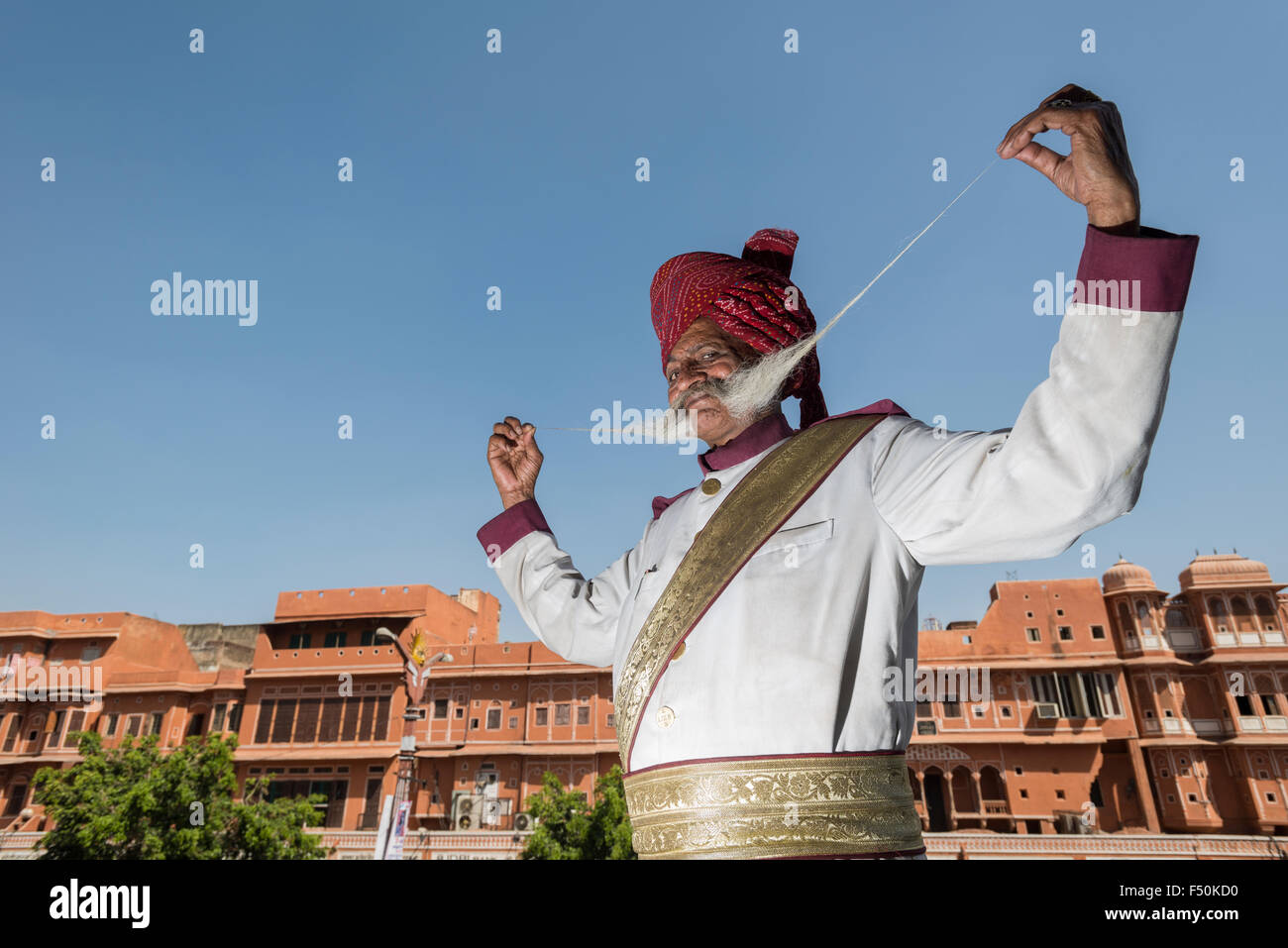 An older man, Rajput, is proudly presenting his more than one meter long mustache in a small street of the old walled Pink City Stock Photo