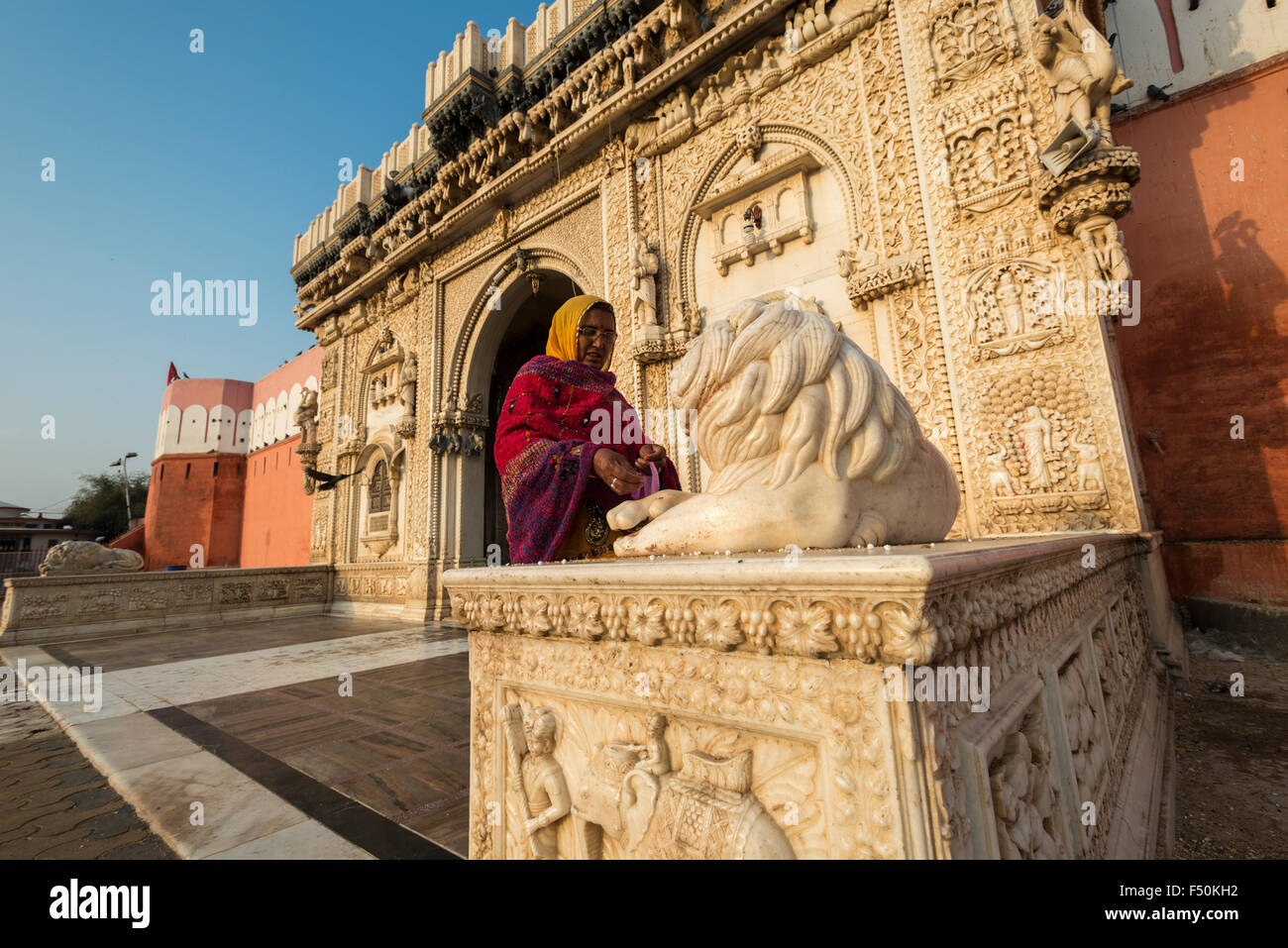 A woman is making an offering at the gate of Karni Mata Temple, a famous Hindu temple dedicated to Karni Mata. It is also known Stock Photo