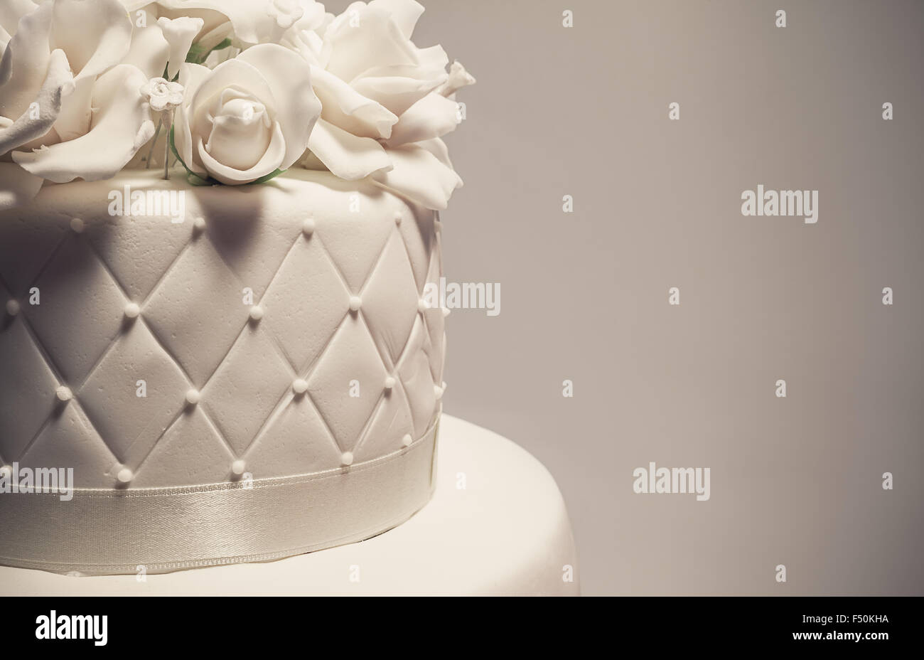 Details of a wedding cake, decoration with white fondant on white background. Stock Photo