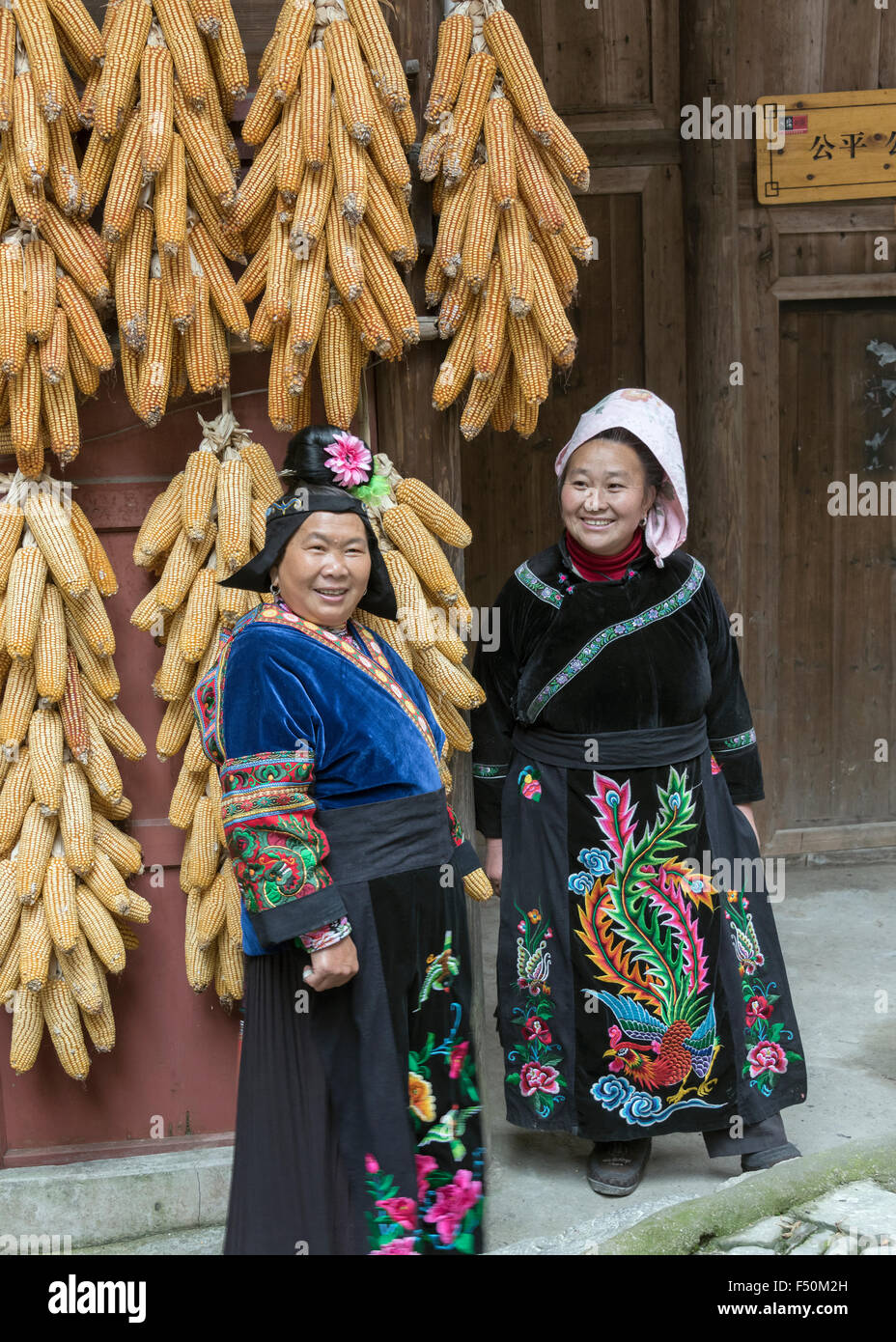 Two village woman in traditional attire with drying corn cobs, Langde ...