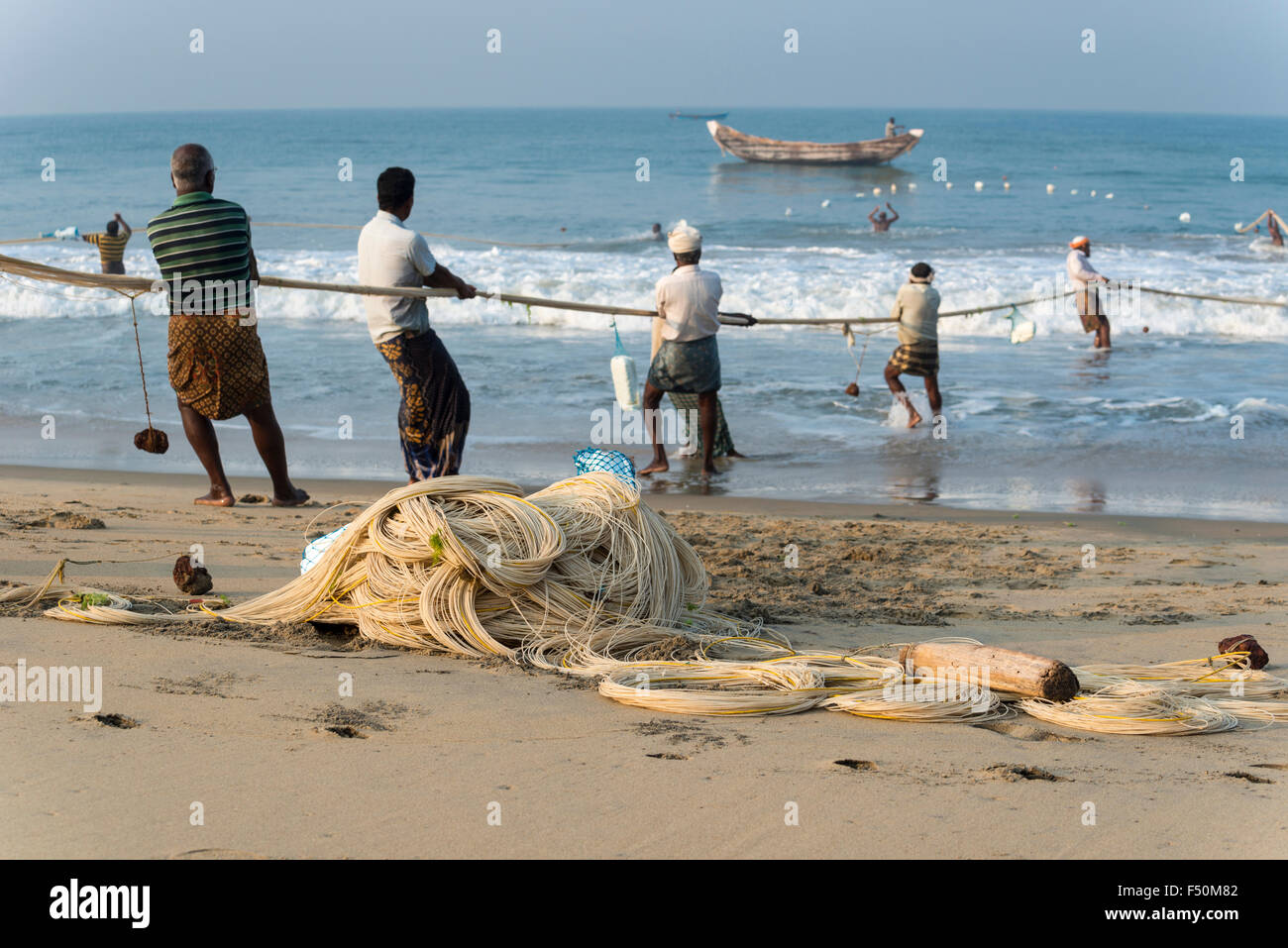 A group of fishermen is pulling out the fishing nets onto the