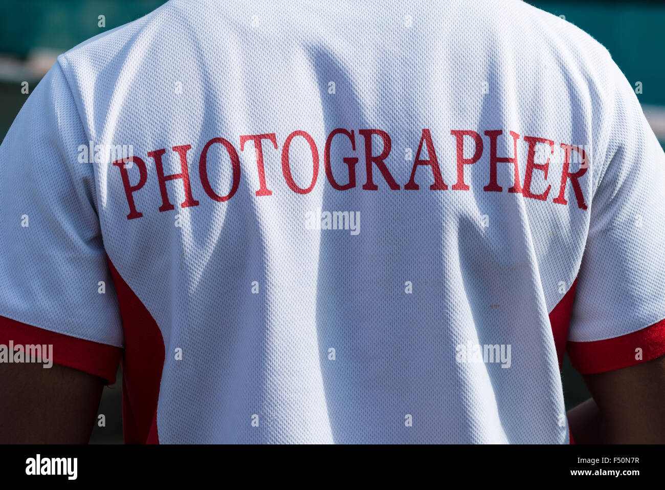 The back of a photographer's shirt with 'Photographer' written on it at Wonder La, the big amusement park outside of Bangalore. Stock Photo