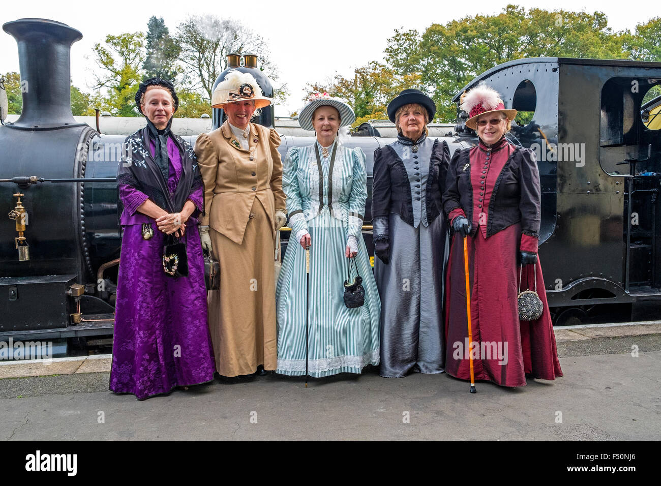 A group of ladies in Victorian dress on the platform at the Bodmin & Wenford steam railway Stock Photo