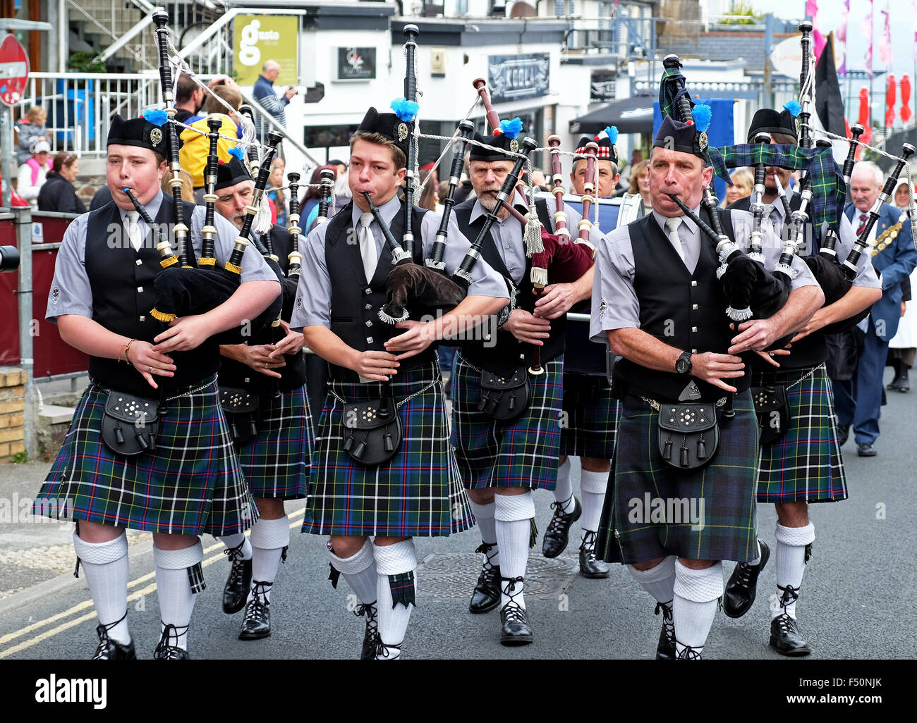 The Truro " pipes and drums " band marching through the streets of