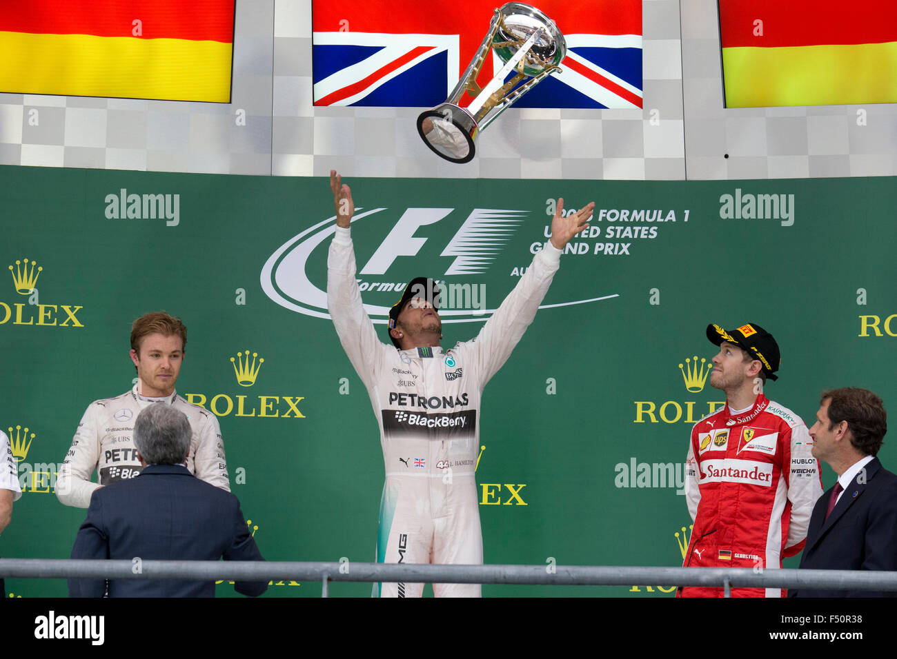 Austin, TX USA October 25, 2015: Formula 1 driver Lewis Hamilton celebrates his victory over teammate Nico Rosberg in the United States Grand Prix that clinched his world championship title. At left is Nico Rosberg in second place and at right is thrid place Sebastian Vettel. Stock Photo