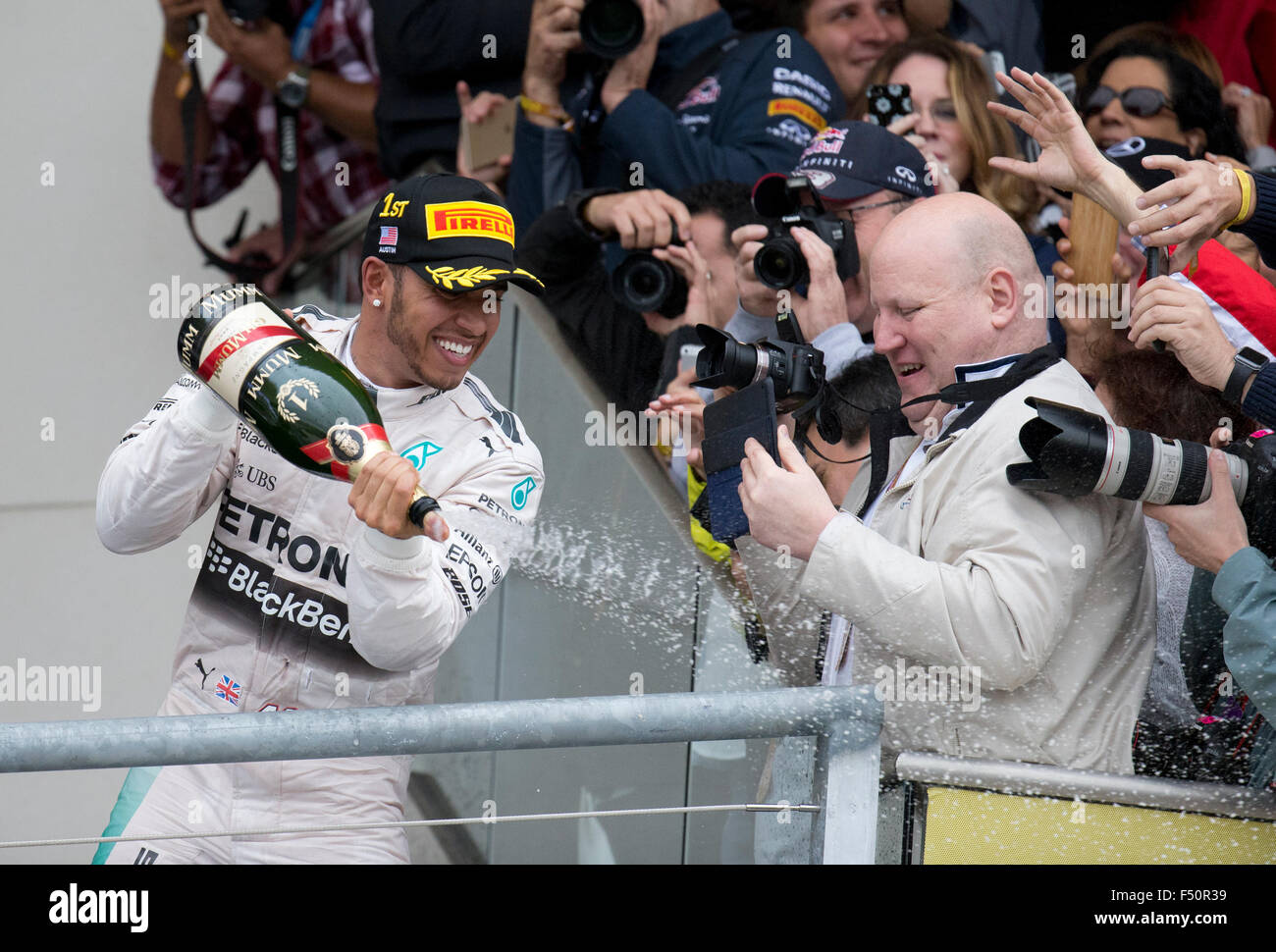 Austin, TX USA October 25, 2015: Formula 1 driver Lewis Hamilton celebrates his victory by spraying champagne over spectators after the United States Grand Prix that clinched his world championship title. Stock Photo