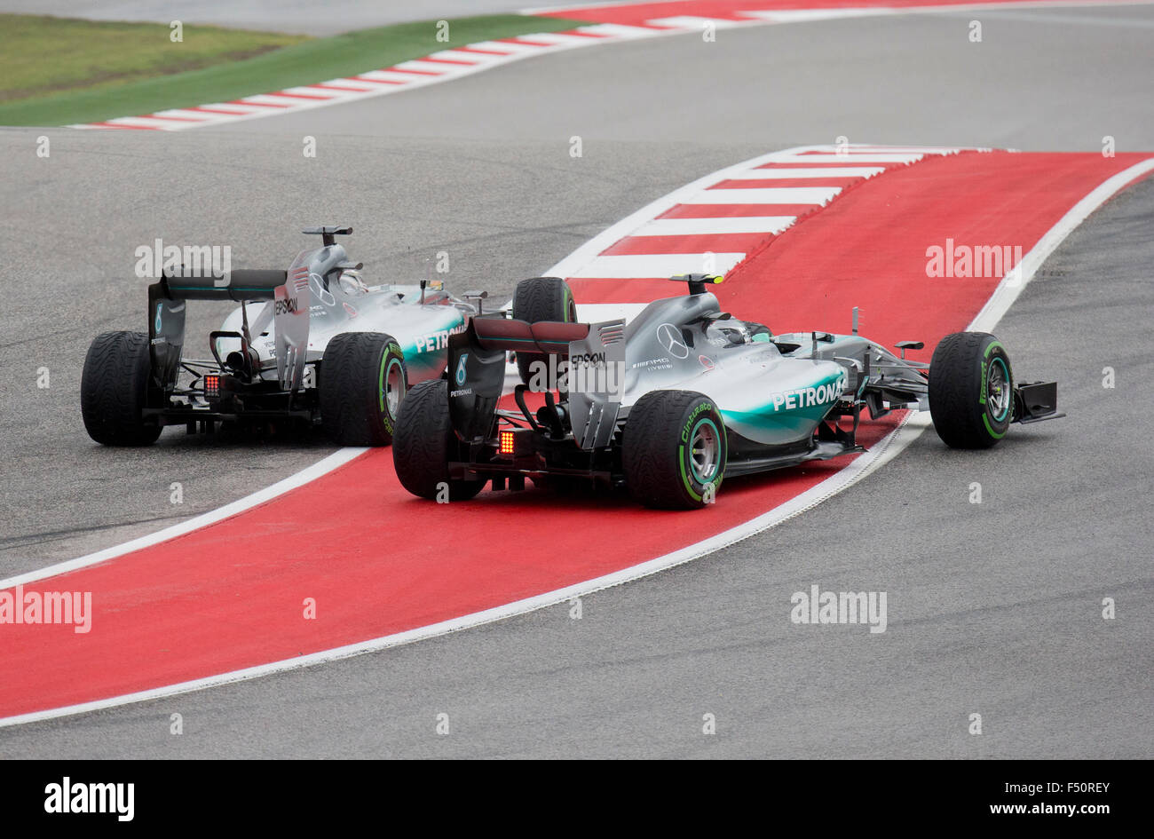 Austin, Texas USA October 25, 2015: Formula 1 teammates Nico Rosberg, left and Lewis Hamilton collide on turn one to start the United States Grand Prix in Austin.  Hamilton won the rain-soaked over Rosberg to give him the world title for 2015. Stock Photo