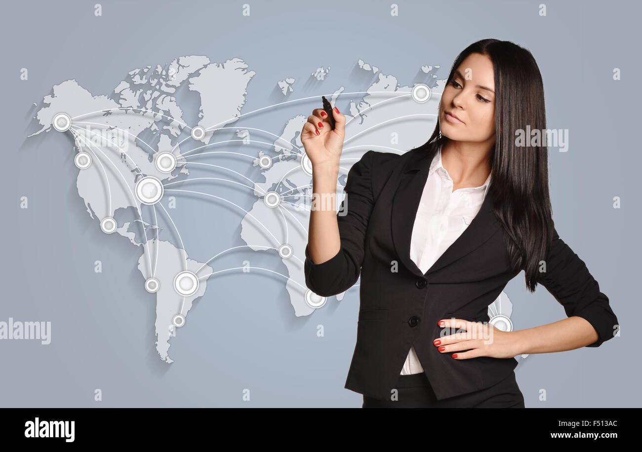 Young girl holding a pen standing on world map background Stock Photo