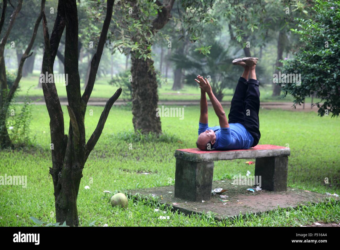 Dhaka, Bangladesh. 21st Oct, 2015. A man exercises early in the morning at Ramna park. Ramna park is a large and recreation area situated at the heart of the central Dhaka of Bangladesh on 21 October, 2015. The history of Ramna starts about 1610 CE during Mughal rule, when the city of Dhaka was founded by Subehdar Islam Khan under Emperor Jahangir. At that time two beautiful residential areas were developed in the northern suburb of Dhaka city. This park is one of the most beautiful areas in Dhaka with lots of trees and a lake near its center. ''ª Photo: Monirul Alam (Credit Image: © Monirul Stock Photo